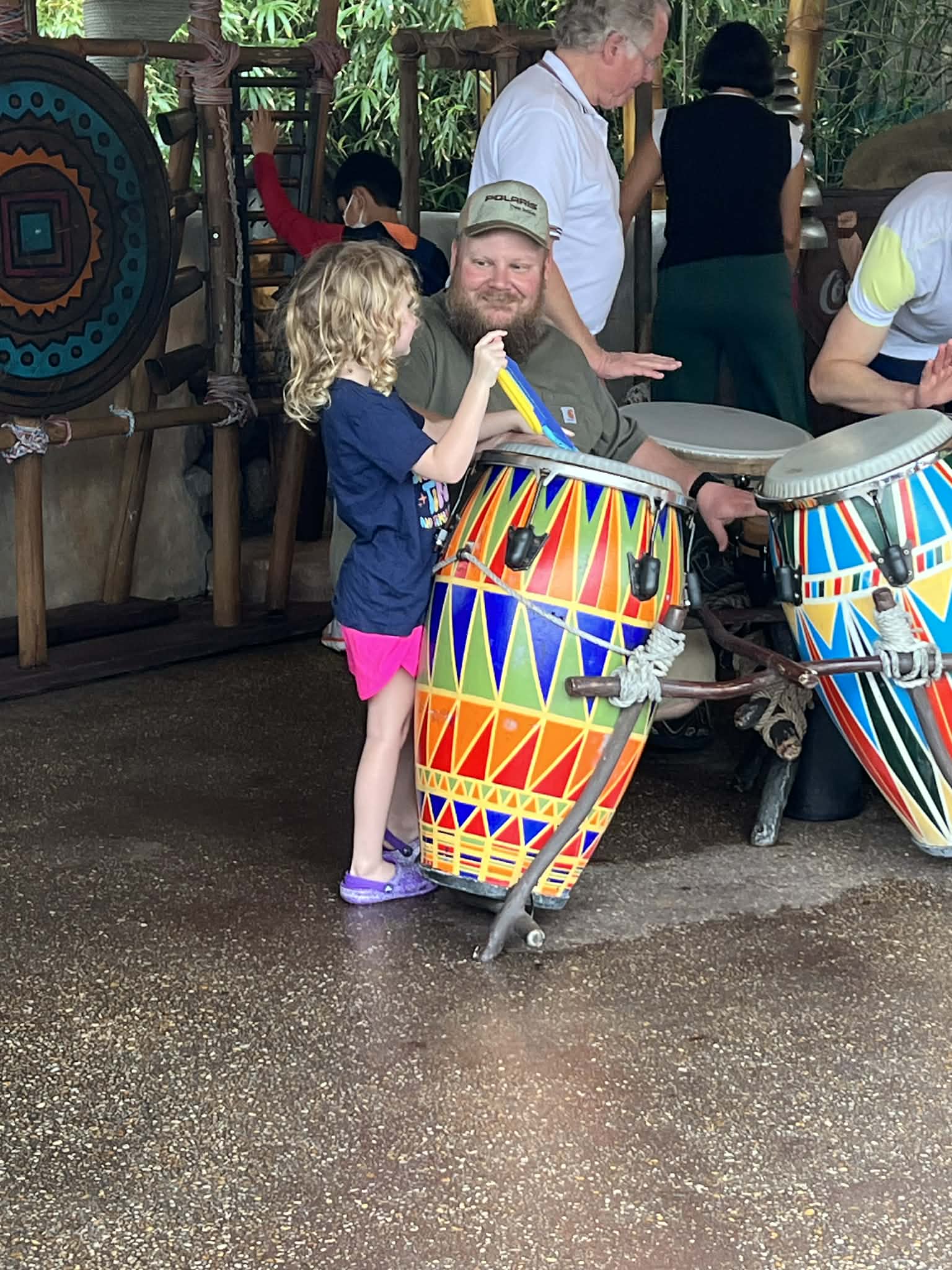 A child joining a drum circle at Epcot