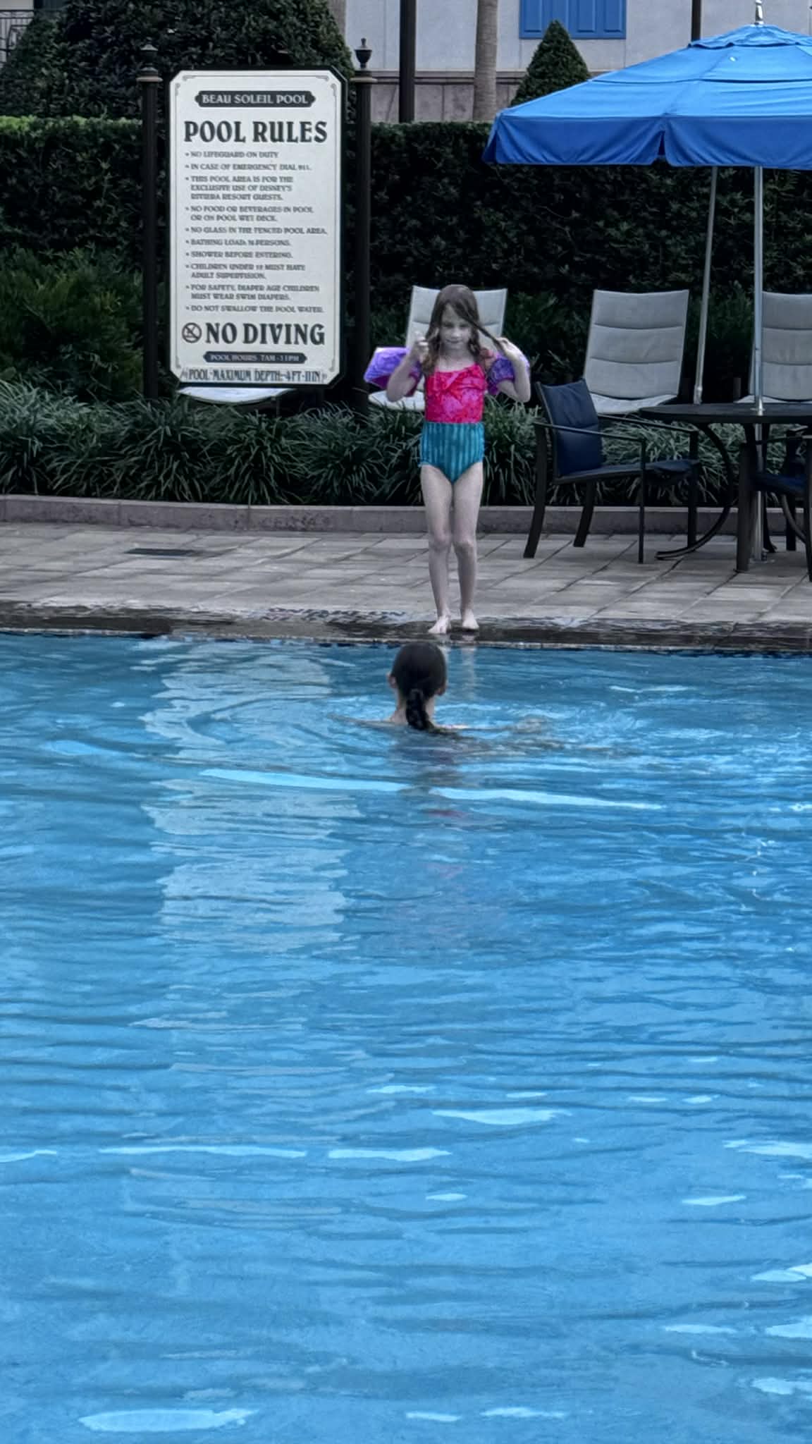 Child playing in a quiet resort pool on vacation
